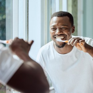 Closeup of man smiling while brushing his teeth