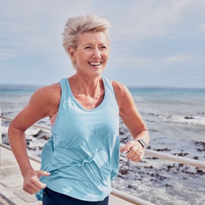 Woman smiling while running on beach