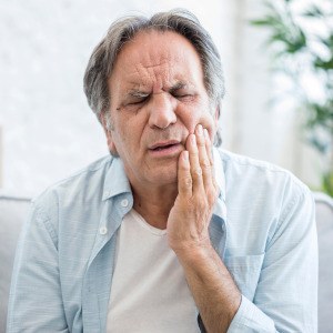 An older man suffering from a toothache