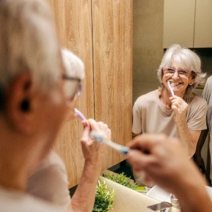 An older couple brushing their teeth in the morning