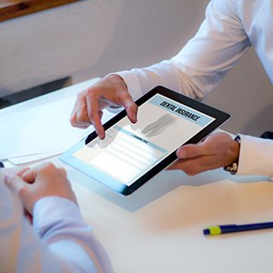 A dental patient looking over a dental insurance form with an insurance agent