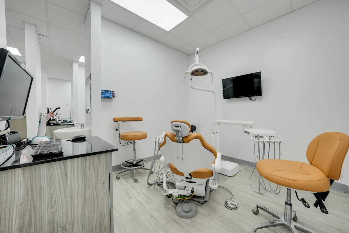 Treatment room at Sonria Dentista Arlington with a dental chair and a wall-mounted TV