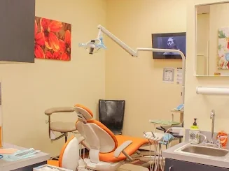 Treatment room at Sonria Dentista Commerce with a dental chair and a wall TV