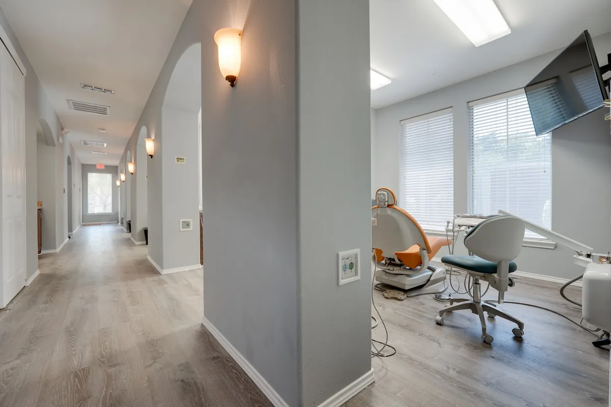 Pasillo y sala de tratamiento con ventanales en Sonria Dentista Grand Prairie